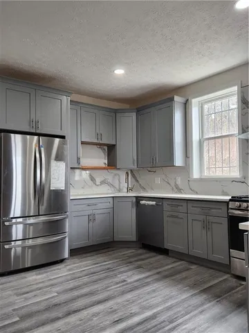 a kitchen with granite countertop stainless steel appliances and wooden cabinets