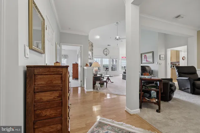a living room with furniture and wooden cabinets