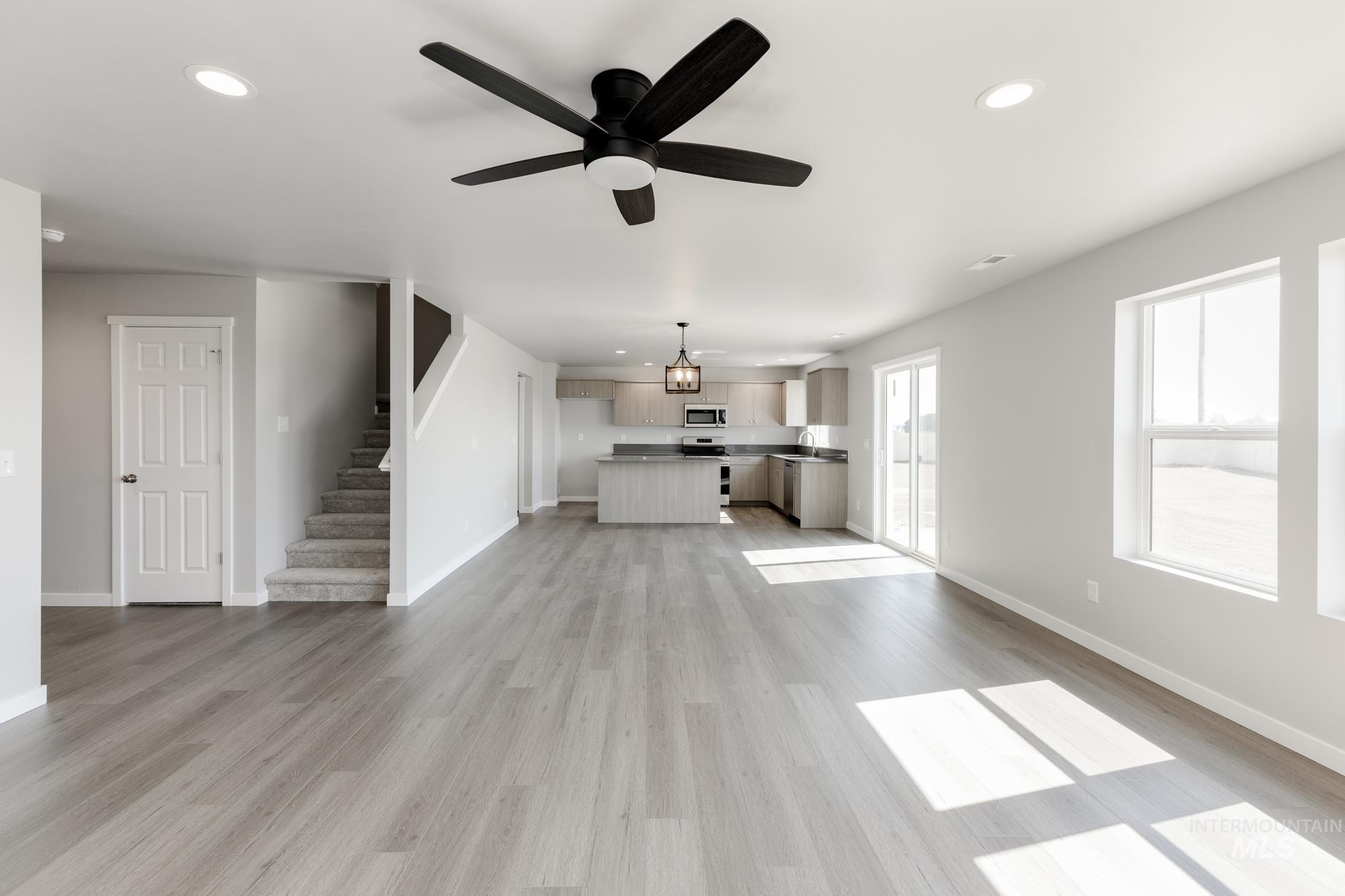 16262 Backfill Place Caldwell, ID 83607 - Photo 11 of 25 Unfurnished living room featuring light wood-type flooring, recessed lighting, ceiling fan, and stairway