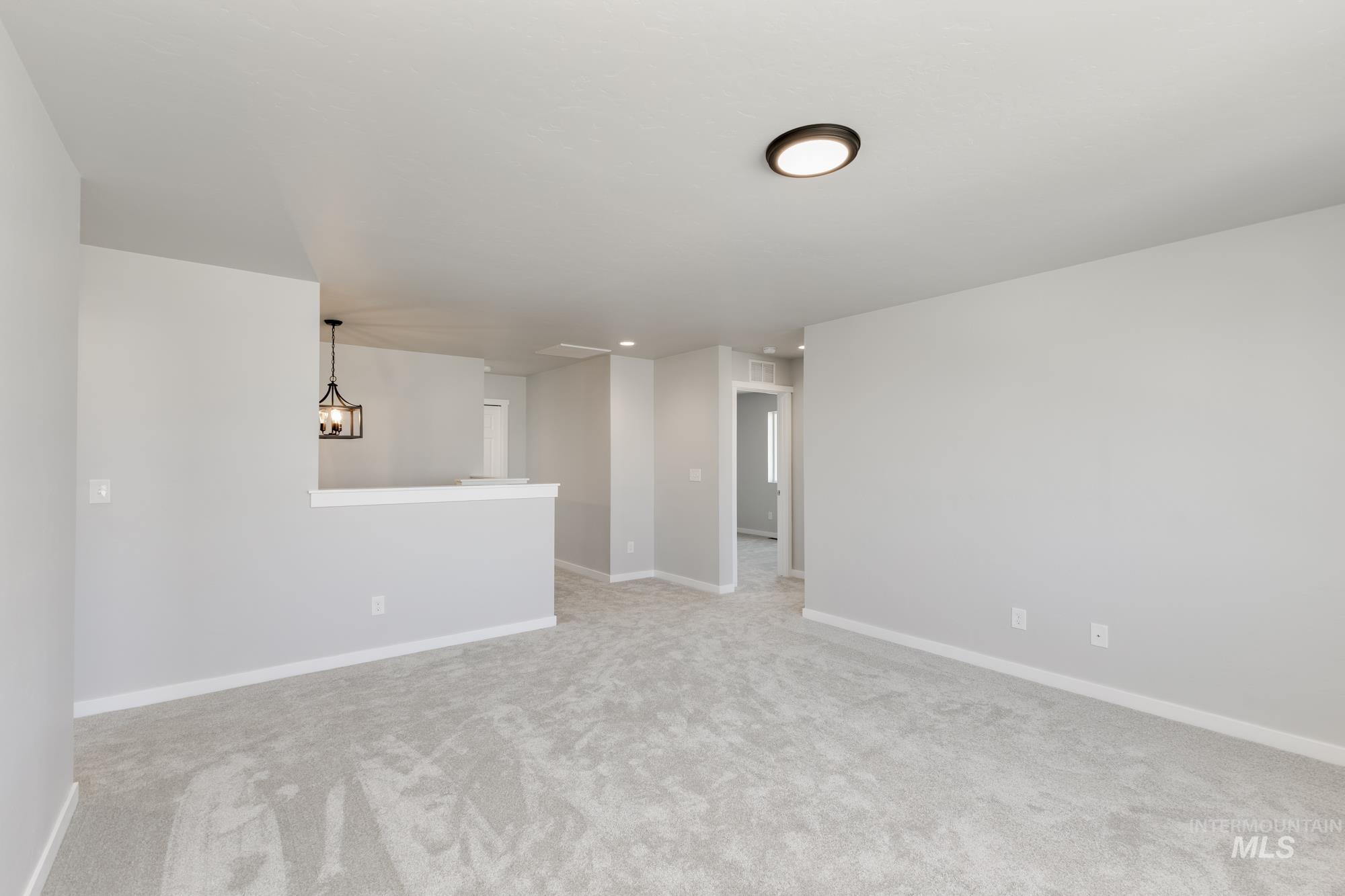 16262 Backfill Place Caldwell, ID 83607 - Photo 15 of 25 Spare room featuring light colored carpet and a chandelier