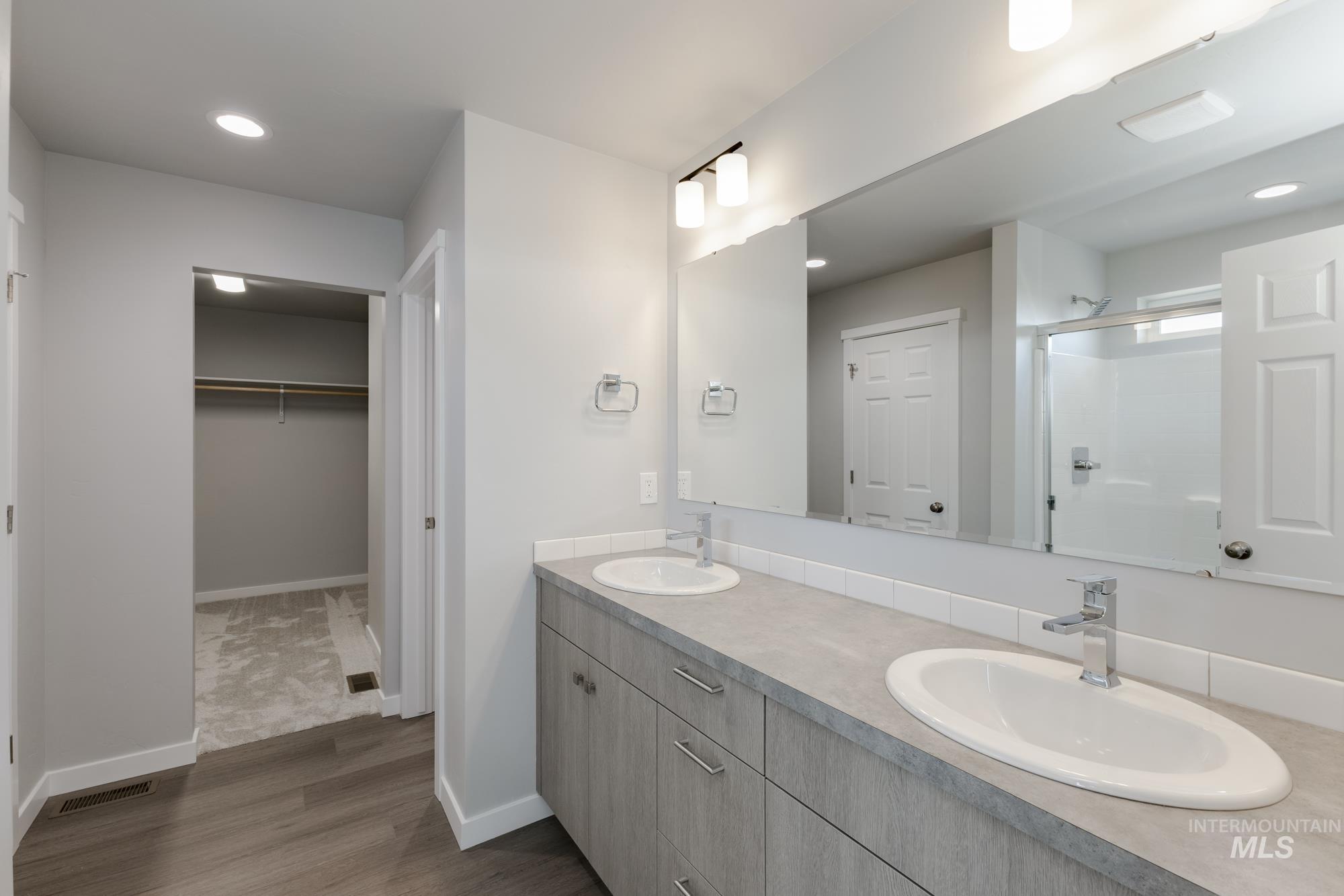 16262 Backfill Place Caldwell, ID 83607 - Photo 24 of 25 Bathroom with a shower stall, double vanity, recessed lighting, a spacious closet, and dark wood-type flooring