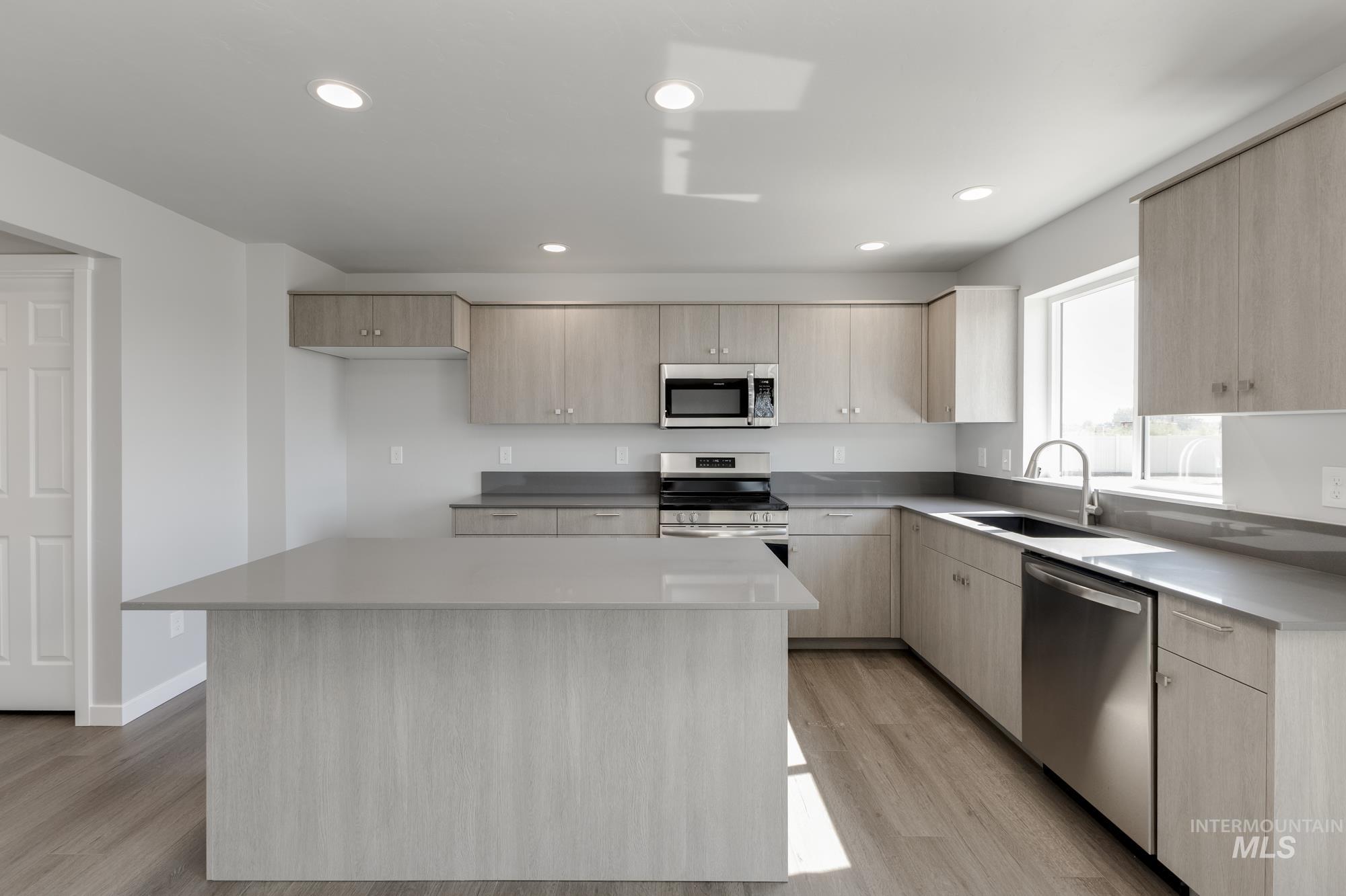 16262 Backfill Place Caldwell, ID 83607 - Photo 5 of 25 Kitchen with light brown cabinetry, stainless steel appliances, modern cabinets, light wood-type flooring, and a kitchen island
