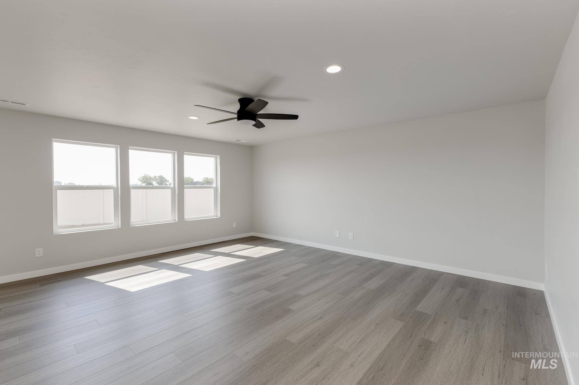 16262 Backfill Place Caldwell, ID 83607 - Photo 8 of 25 Unfurnished room with light wood-type flooring, recessed lighting, and a ceiling fan