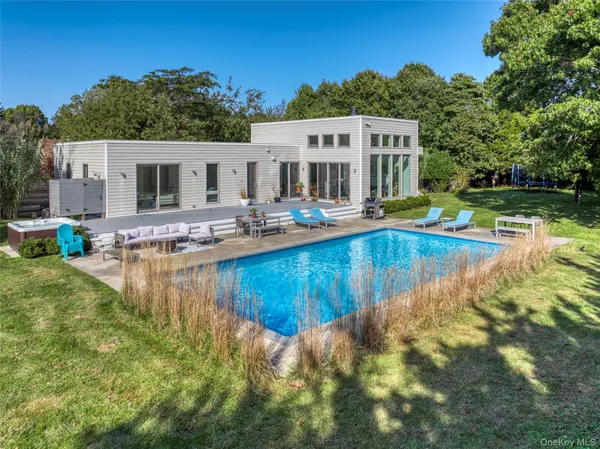 a view of a house with pool and chairs