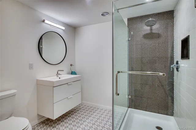 a bathroom with a toilet a sink and mirror