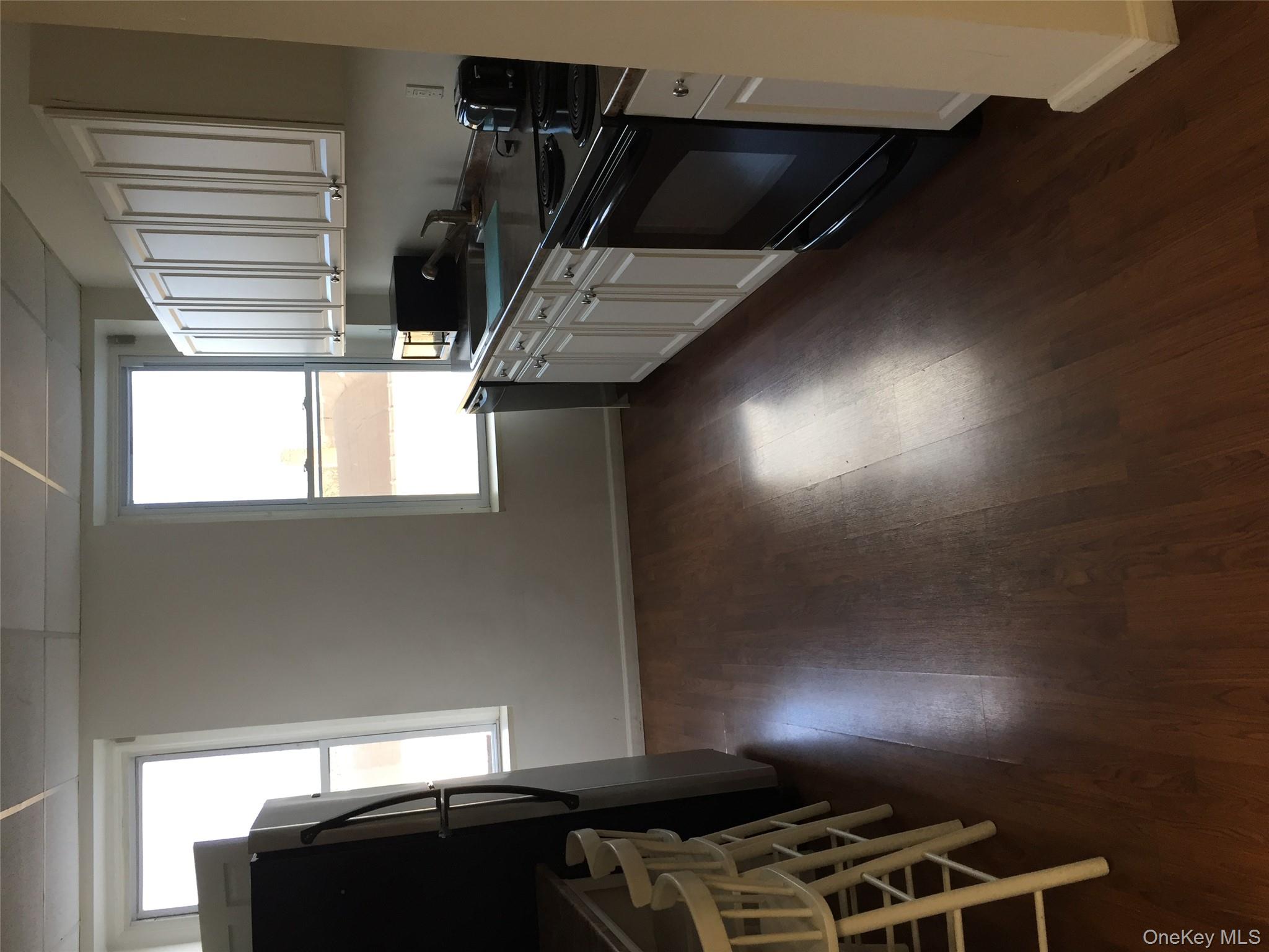 249 Main Street, Unit EAST Huntington, NY 11743 - Photo 6 of 11 a kitchen with granite countertop a stove a sink and a window