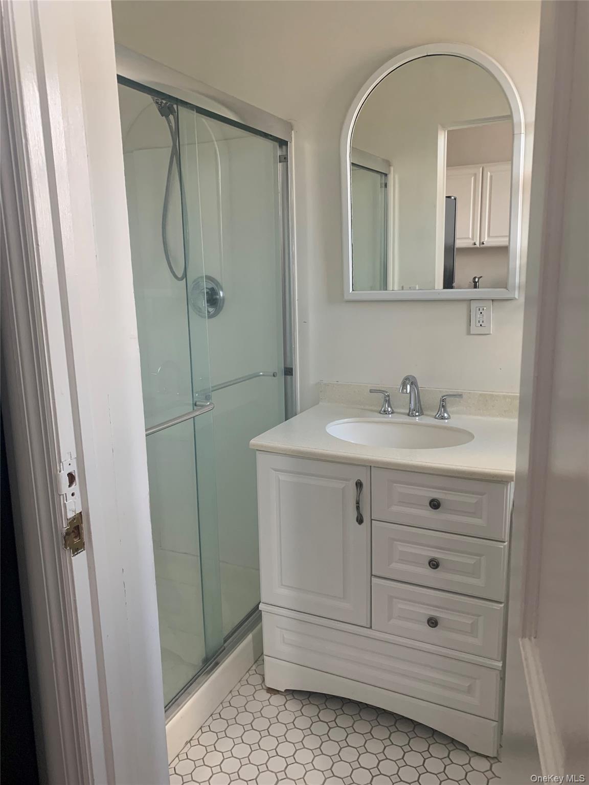 249 Main Street, Unit EAST Huntington, NY 11743 - Photo 10 of 11 a bathroom with a sink a mirror a vanity and a shower