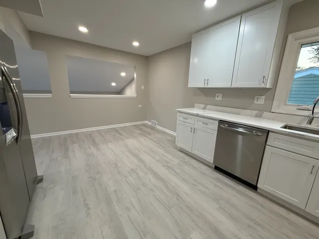 an empty room with wooden floor and window