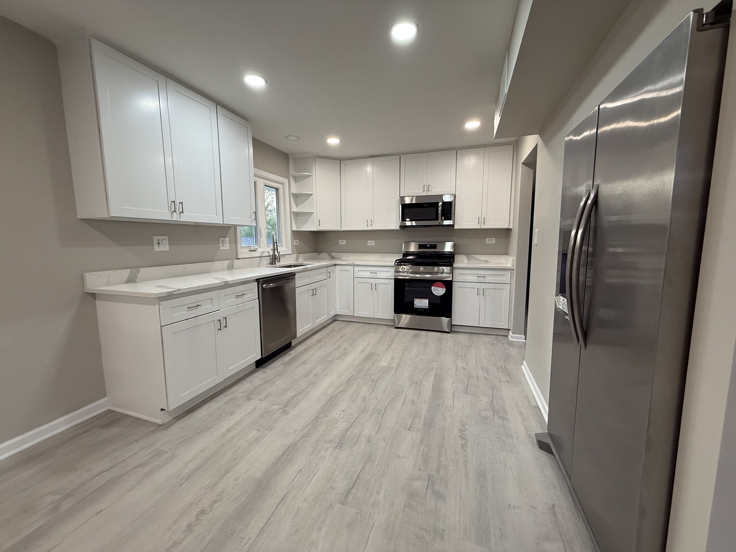 337 Woodland Drive Grayslake, IL 60030 - Photo 12 of 35 a kitchen with stainless steel appliances granite countertop a refrigerator a sink dishwasher a stove and a refrigerator with wooden floor
