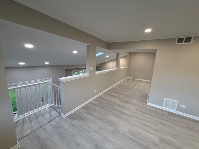 a view of an empty room with wooden floor