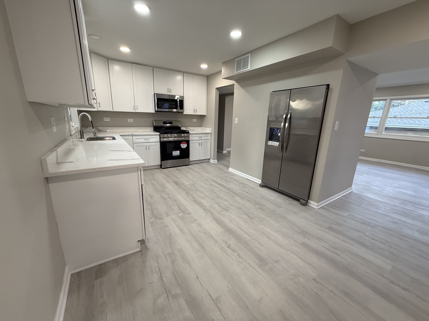 337 Woodland Drive Grayslake, IL 60030 - Photo 5 of 35 a kitchen with stainless steel appliances granite countertop a sink a stove a refrigerator cabinets and a wooden floor
