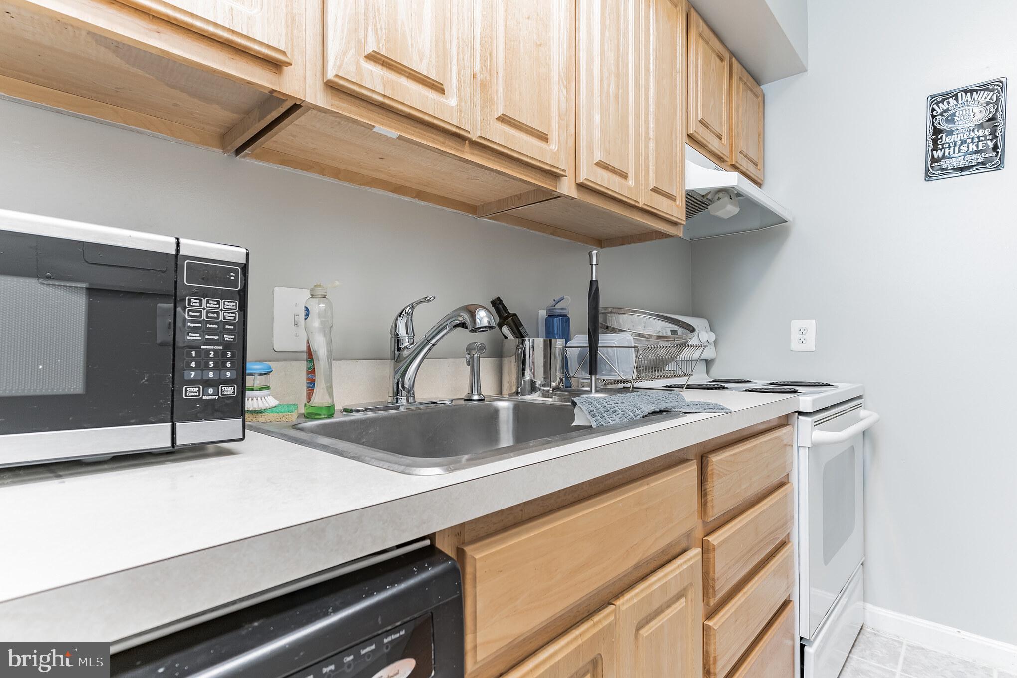 1208 1/2 33rd Street Northwest Washington, DC 20007 - Photo 14 of 30 a kitchen with stainless steel appliances a sink and cabinets