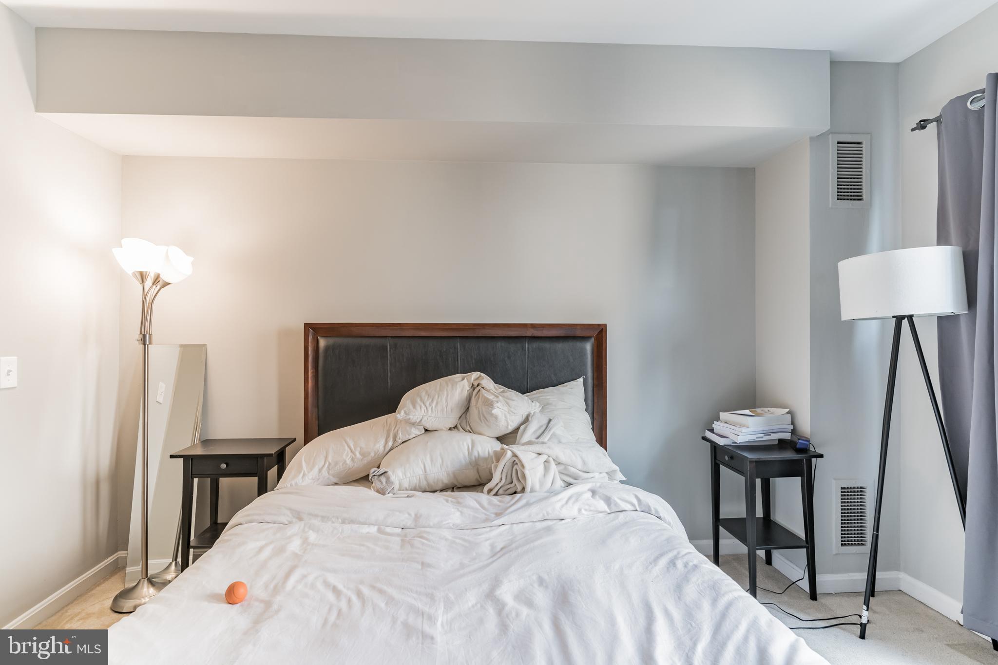 1208 1/2 33rd Street Northwest Washington, DC 20007 - Photo 17 of 30 a large bed sitting in a bedroom next to a lamp