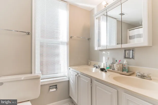 a bathroom with a sink a toilet and a window