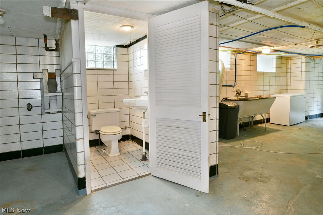 892 Yankee Run Road Masury, OH 44438 - Photo 49 of 50 Bathroom featuring white ceramic wall tile, white ceramic floor tile, and a white toilet