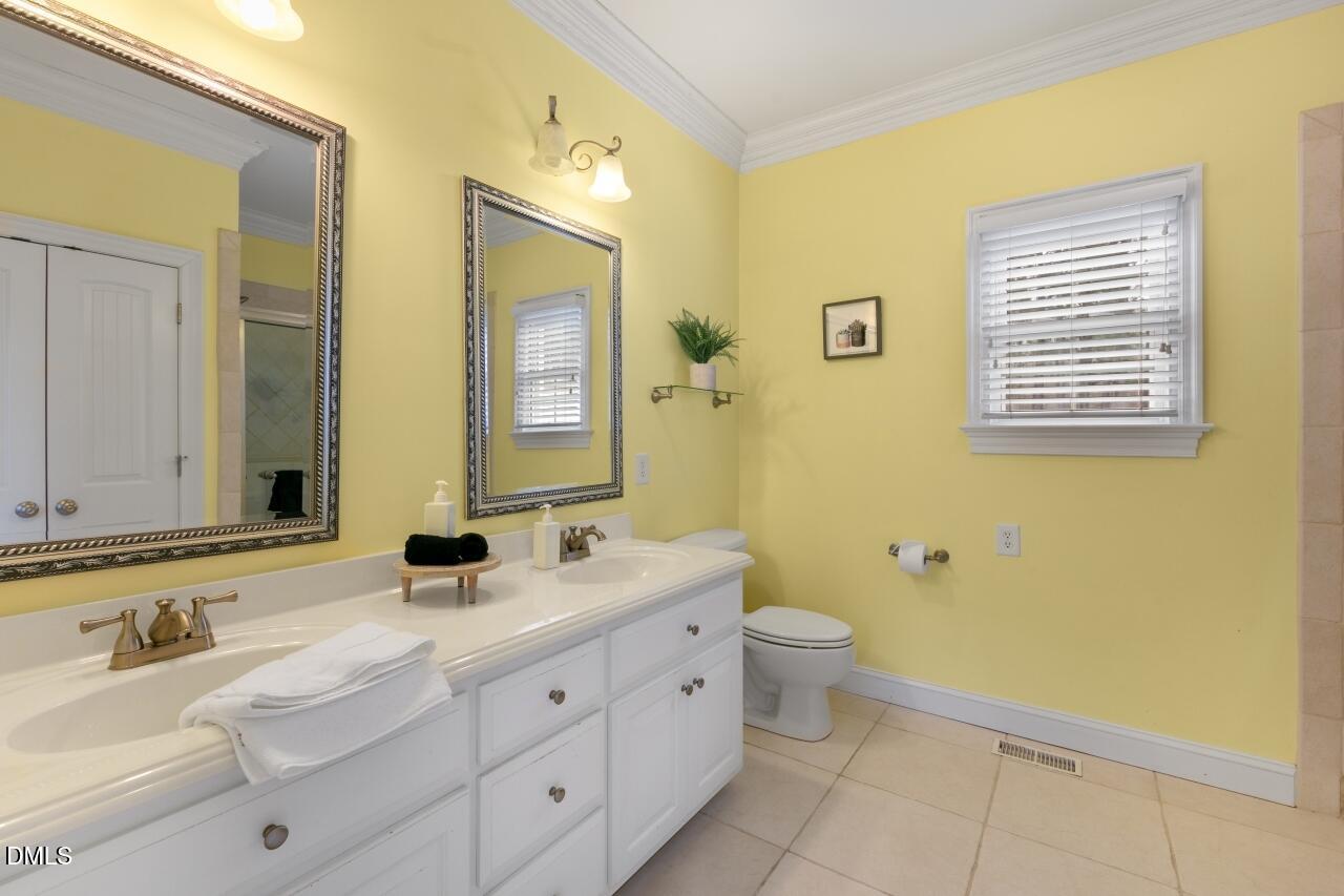 9199 Fox Run Road Bailey, NC 27807 - Photo 9 of 36 a bathroom with a double vanity sink toilet and a mirror