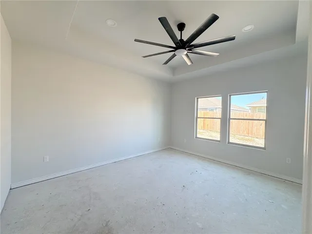 an empty room with windows and fan
