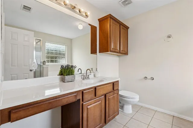 a bathroom with a granite countertop toilet sink and mirror