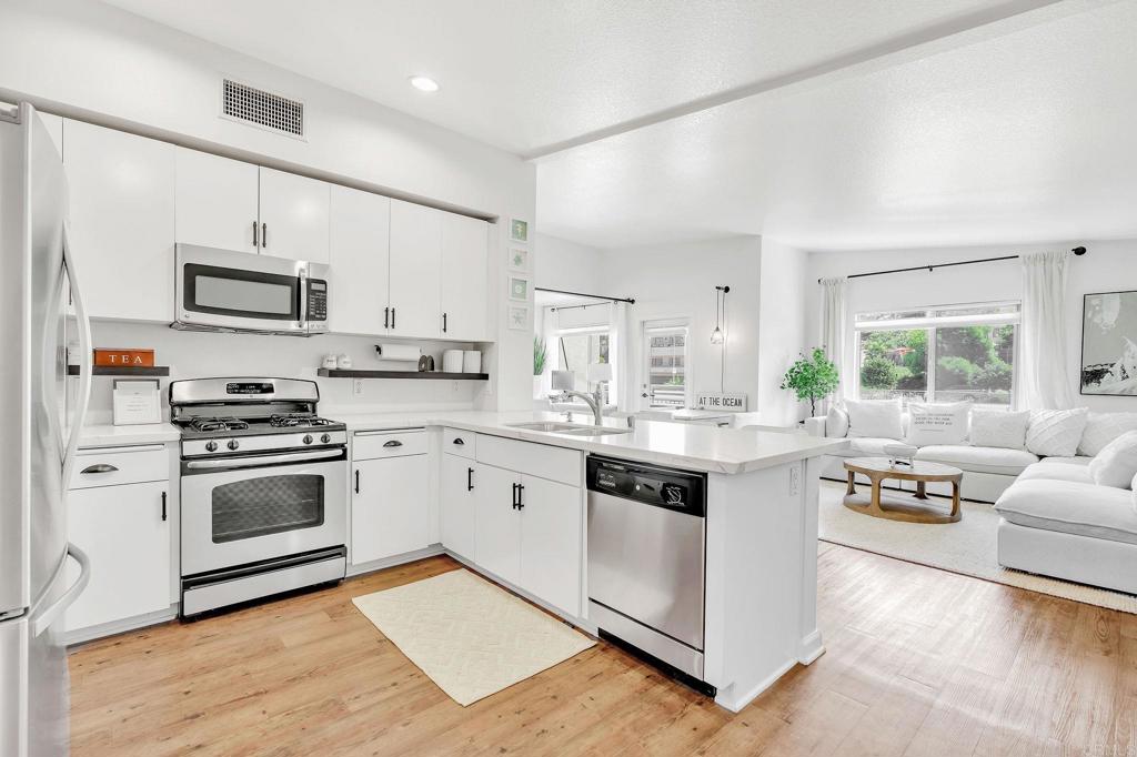 a kitchen with stainless steel appliances white cabinets a sink and a stove