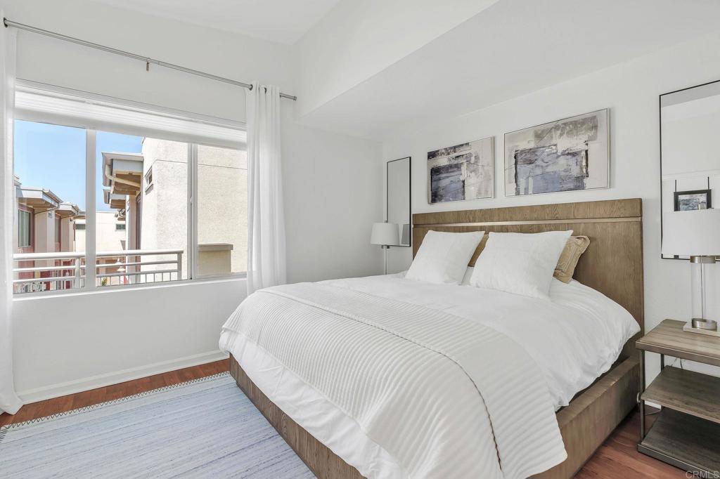 687 South Coast Highway 101, Unit 302 Encinitas, CA 92024 - Photo 13 of 32 a bedroom with a large bed and a window