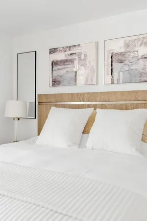 a bed with a white comforter and pillows
