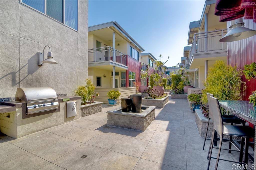 687 South Coast Highway 101, Unit 302 Encinitas, CA 92024 - Photo 31 of 32 a view of a patio with couches and table and potted plants