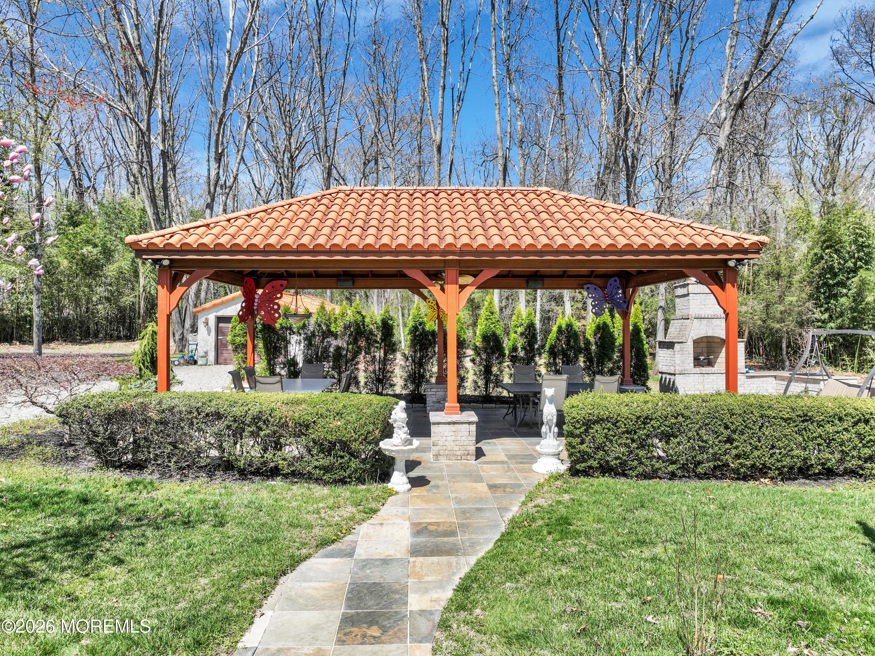 12 Red Fox Run Manalapan, NJ 07726 - Photo 47 of 57 a view of a patio with table and chairs under an umbrella with large trees
