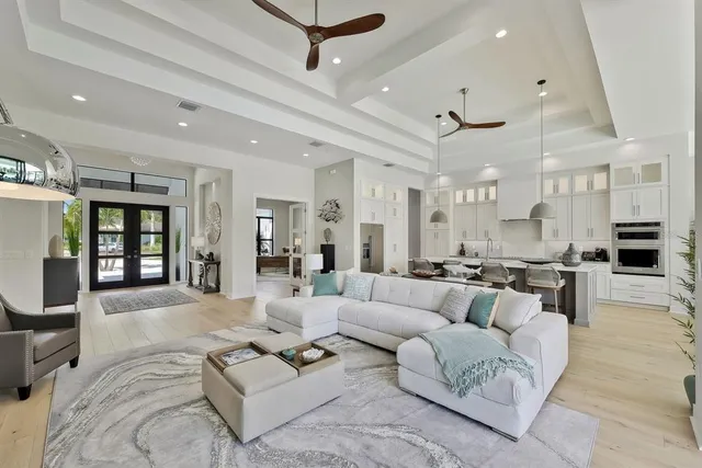 a living room with furniture kitchen view and a large window
