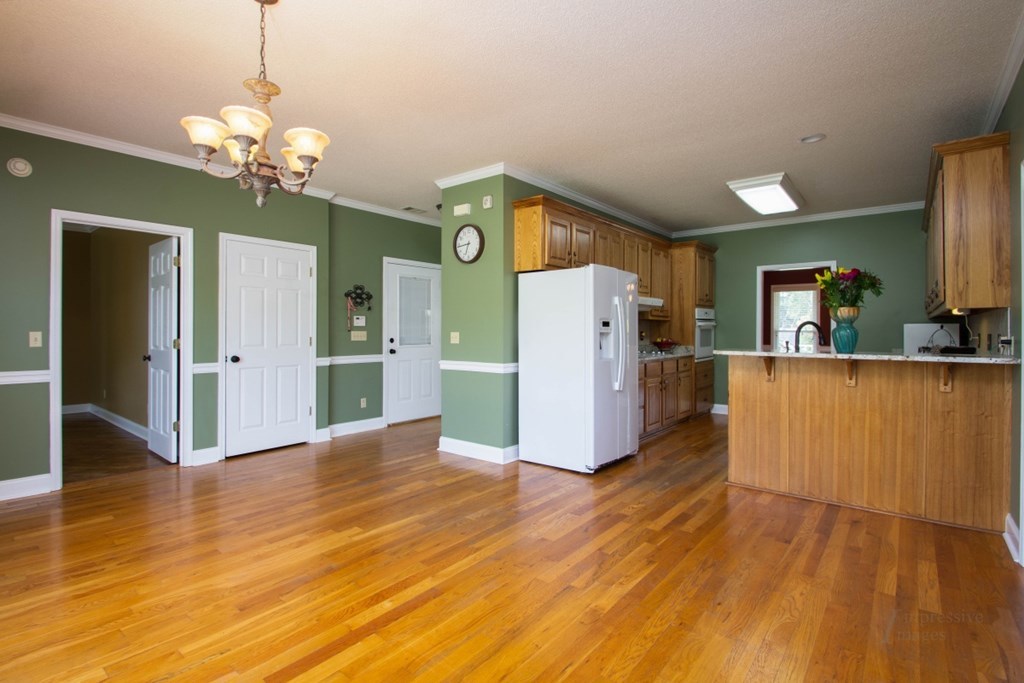 885 Jenkins Road, Unit 14 Forsyth, GA 31029 - Photo 11 of 33 a view of a kitchen with a refrigerator wooden floor and a living room