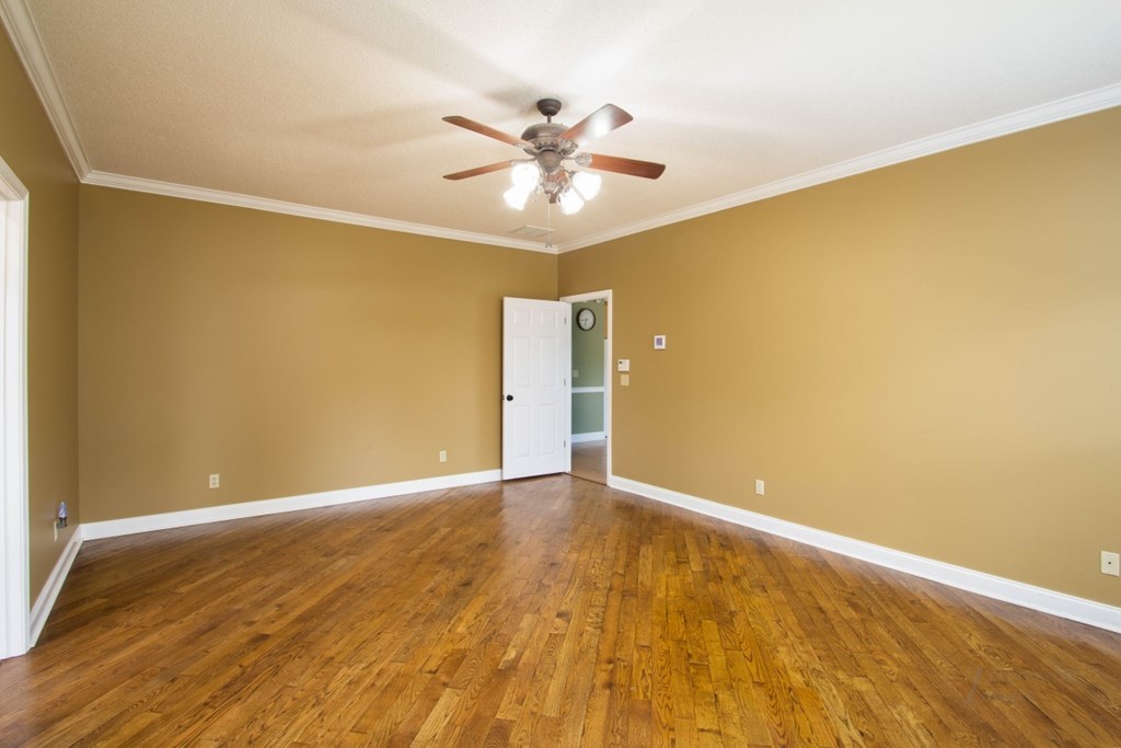 885 Jenkins Road, Unit 14 Forsyth, GA 31029 - Photo 13 of 33 a view of an empty room with wooden floor and a ceiling fan