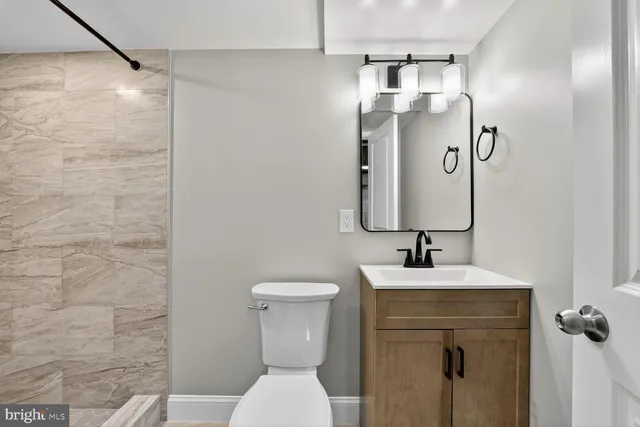 a bathroom with a toilet sink and mirror
