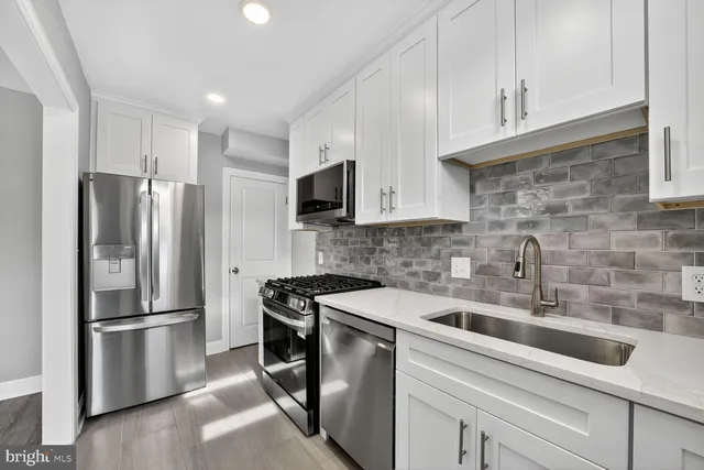 a kitchen with stainless steel appliances a refrigerator sink and cabinets