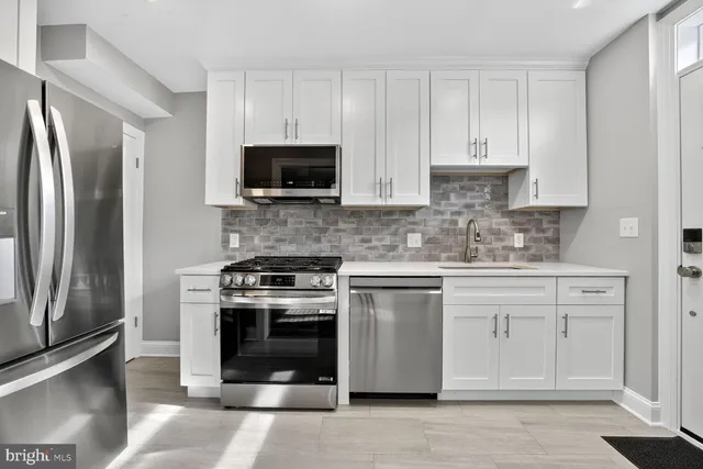 a kitchen with cabinets stainless steel appliances and a counter space