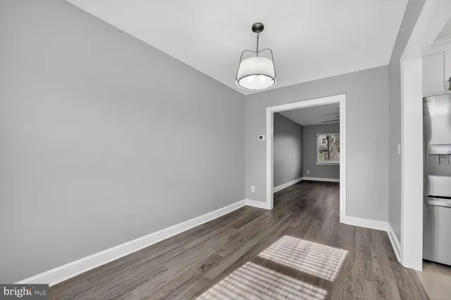 a view of a hallway with wooden floor and a chandelier