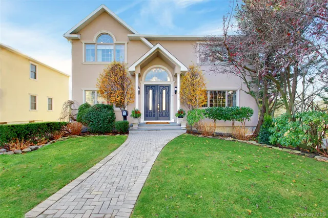 a front view of a house with a yard and potted plants