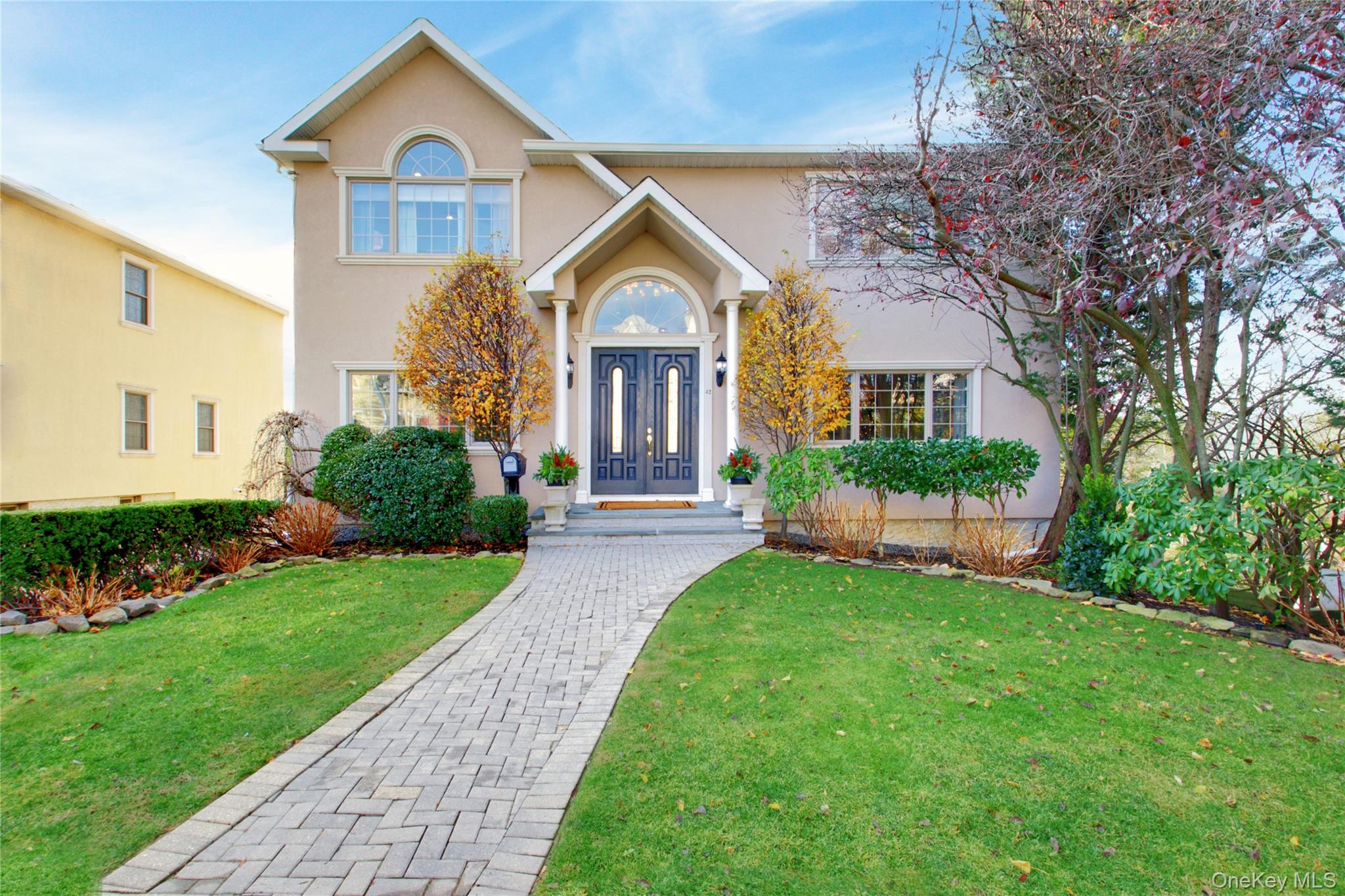 a front view of a house with a yard and potted plants