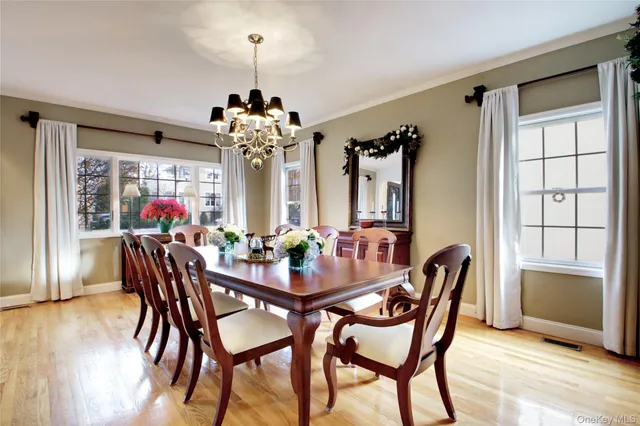 a dining room with furniture wooden floor and a chandelier