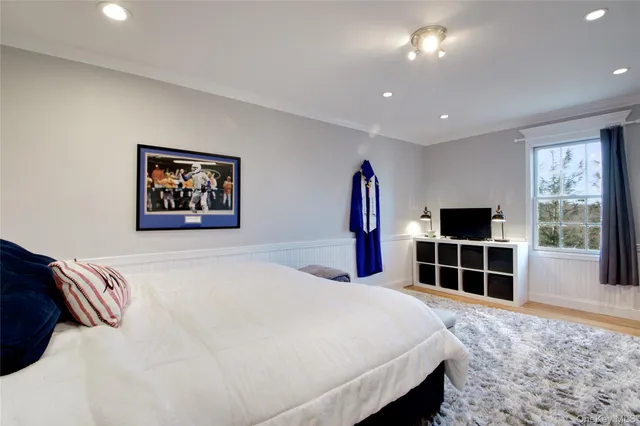 a bedroom with a bed a chandelier and large window