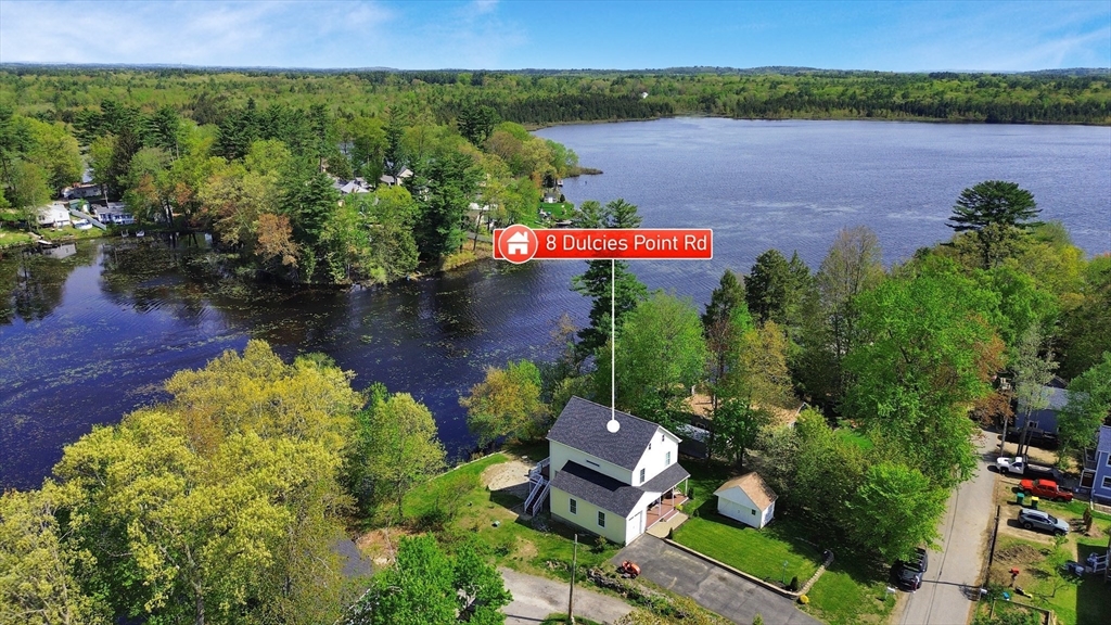 an aerial view of a house with garden space and lake view