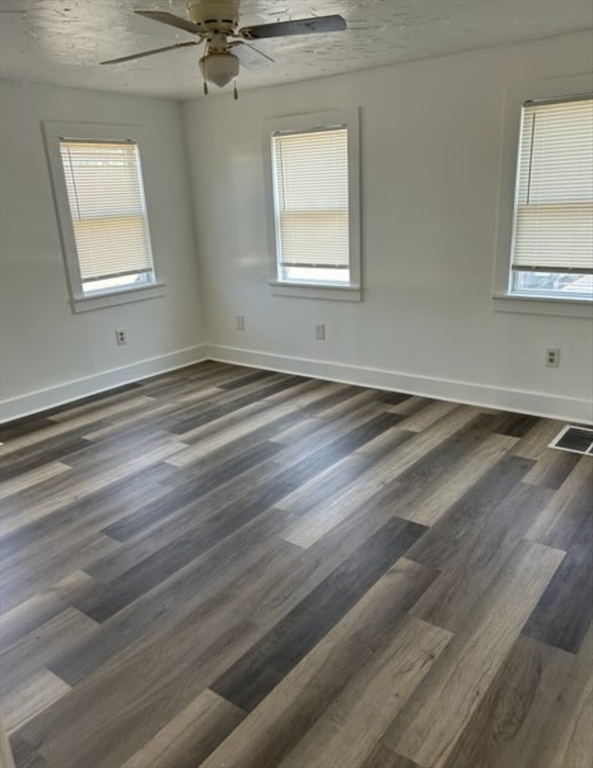 87 North High Street, Unit A Derry, NH 03038 - Photo 5 of 9 an empty room with wooden floor and windows