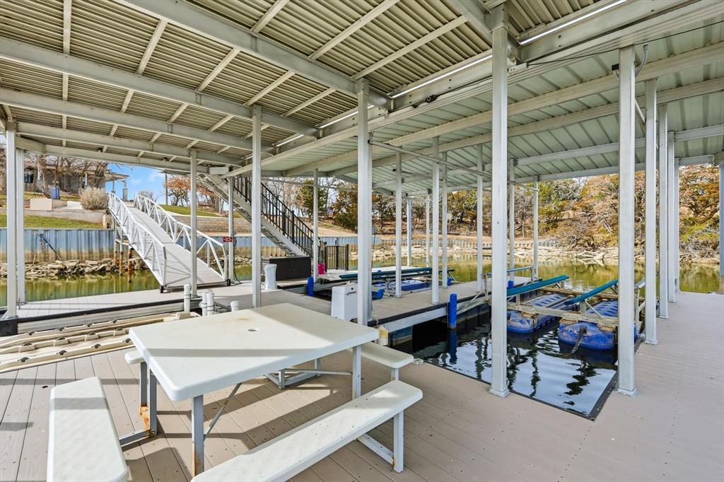 8799 County Road 299 Graham, TX 76450 - Photo 11 of 34 A beautiful view of the house, broad walkway leading to the dock, where multiple watercraft slips sit alongside a stairway that offers seamless access up to the expansive, single level sun deck for sunning, jumping off the rope swing lake fun!