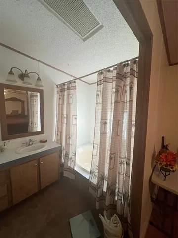 a bathroom with a tub sink and mirror