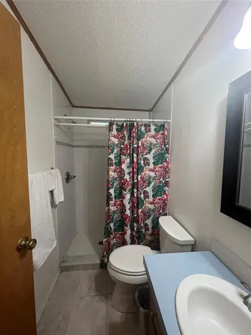 a white toilet sitting next to a bathroom sink and a shower