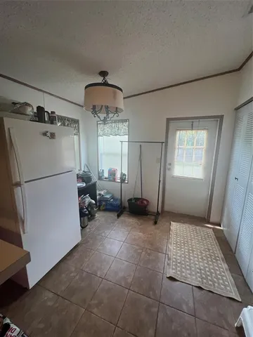 a view of kitchen with furniture and refrigerator