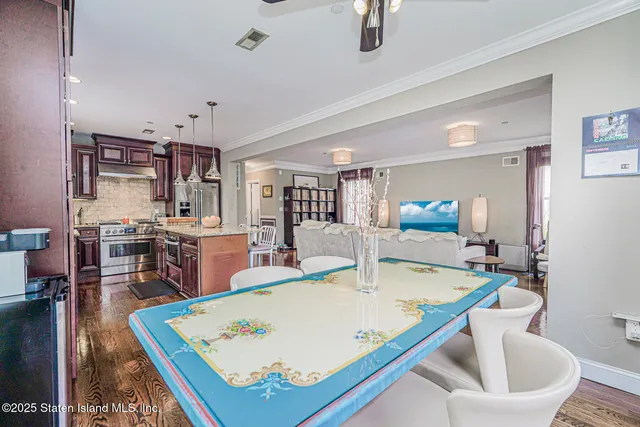 a kitchen with stainless steel appliances granite countertop a stove a sink a microwave a dining table and chairs