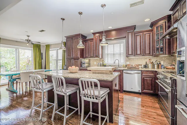 a kitchen with kitchen island granite countertop a sink stove and refrigerator
