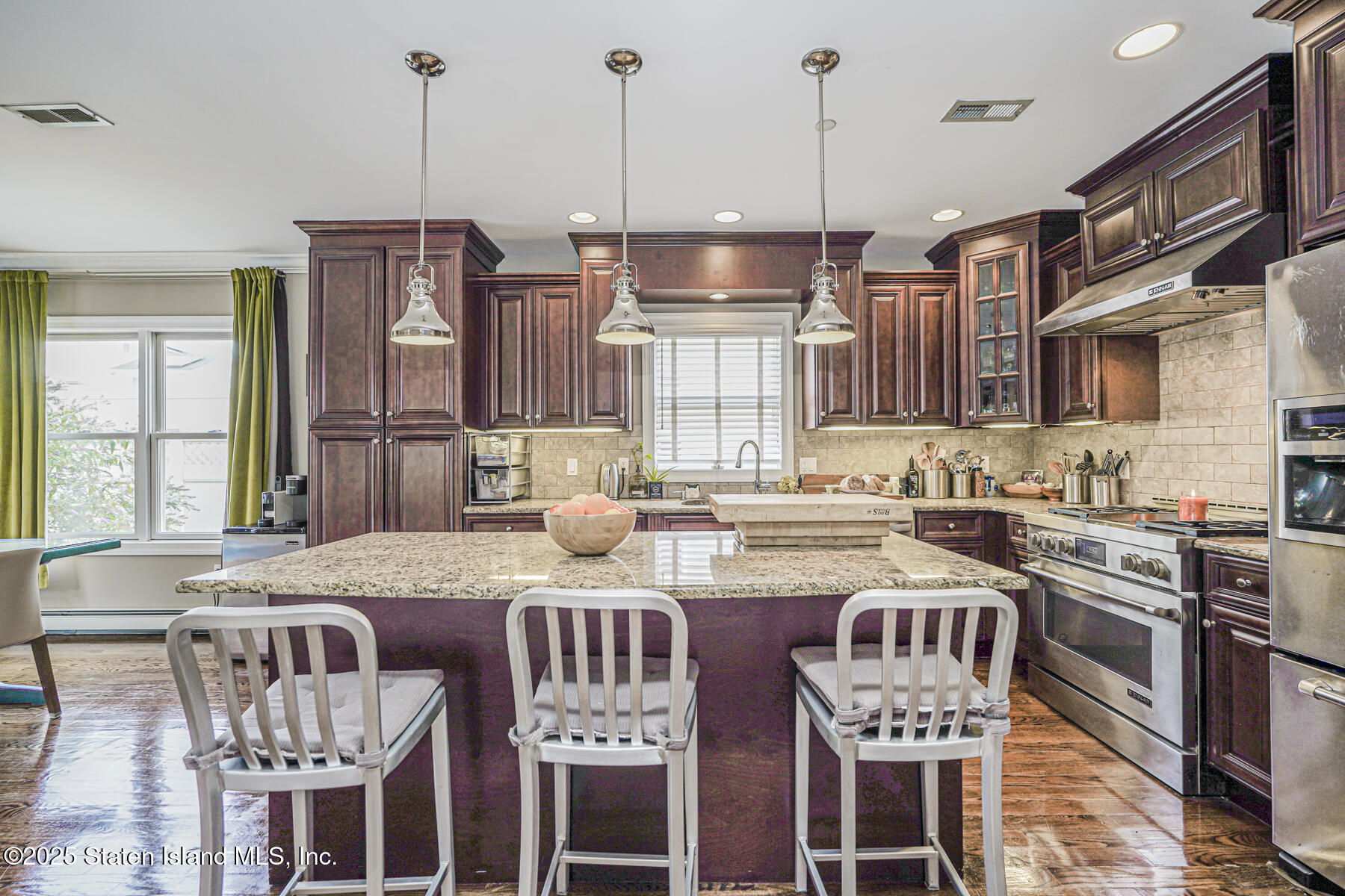 28 Brookside Loop Staten Island, NY 10309 - Photo 17 of 60 a kitchen with stainless steel appliances granite countertop a stove a sink a microwave a dining table and chairs