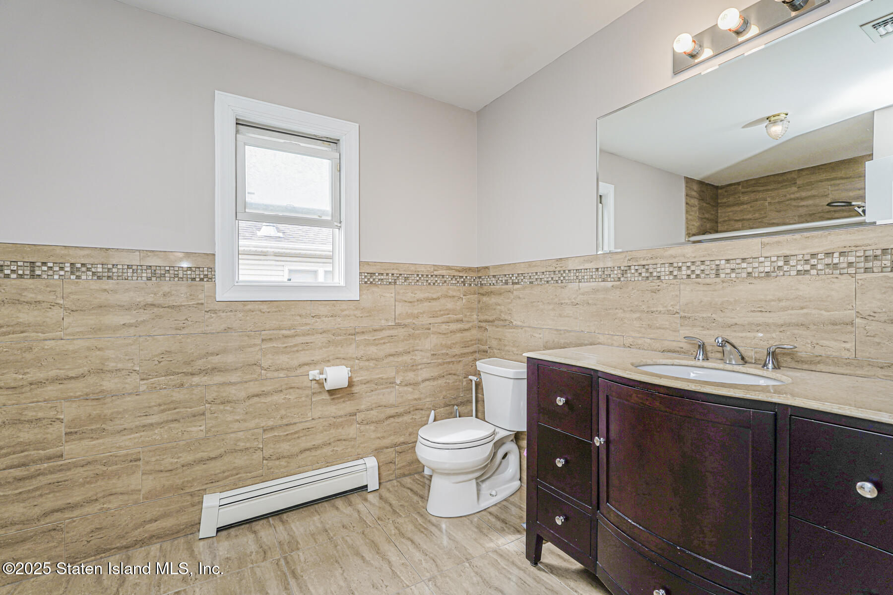 28 Brookside Loop Staten Island, NY 10309 - Photo 39 of 60 a bathroom with a toilet a sink a mirror a window and vanity