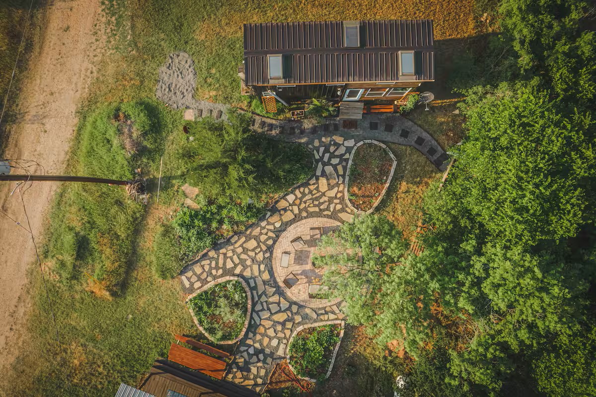 16107 Fagerquist Road Del Valle, TX 78617 - Photo 17 of 17 An aerial perspective reveals a cozy home nestled amidst lush greenery and a charming flagstone pathway.