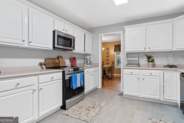 a kitchen with white cabinets and white appliances